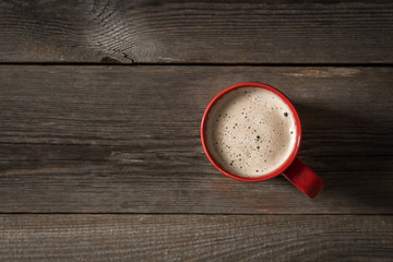 Red Coffee cup on wooden table. View from top 