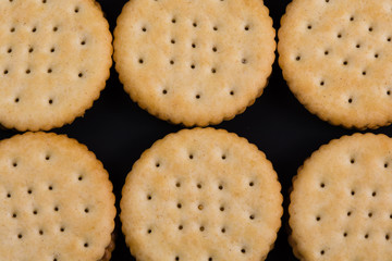 Round crackers lined up on black background