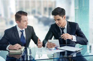 Two businessman using tablet in meeting