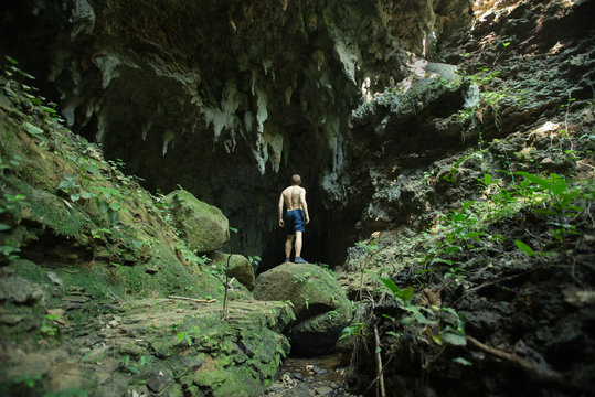 Man looking into empty limestone cave