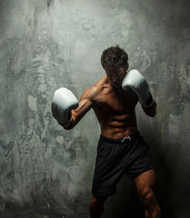 Awesome male boxing on grey background.