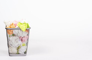 isolated wastebasket full of color waste paper