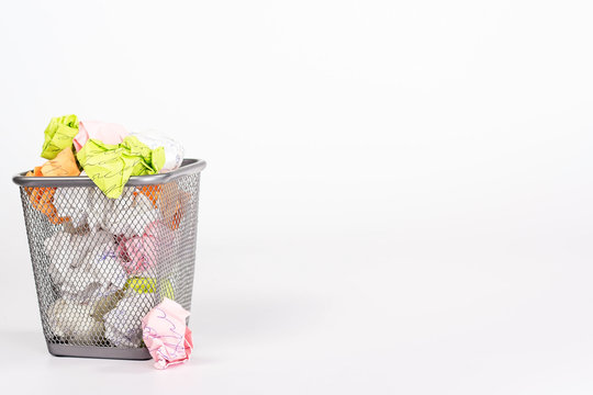 isolated wastebasket full of color waste paper