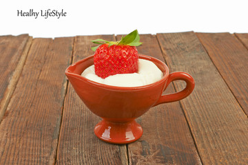 Yogurt with strawberries on a wooden table