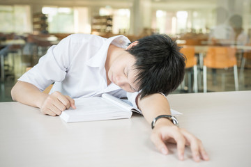 Asian student lying and sleeping on the school desk
