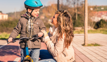 Obraz premium Young woman with child over bicycle on sunny day