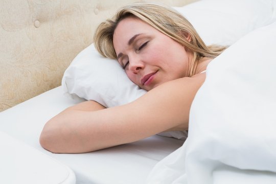 Pretty blonde lying in bed sleeping