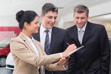 Smiling business team working together on clipboard