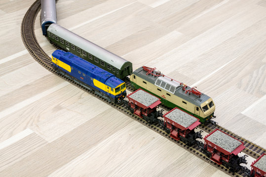 Two model trains on wooden floor, game for kids
