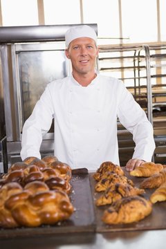 Smiling baker showing board of breads