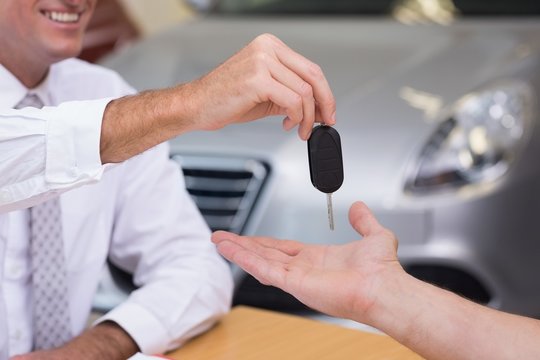 Salesman giving a customer car keys