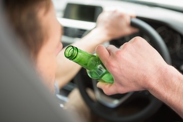 Man drinking beer while driving