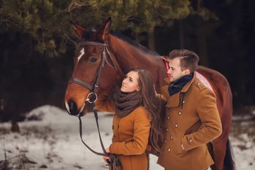 Foto op Canvas young couple walking through the forest with a horse © jozzeppe777