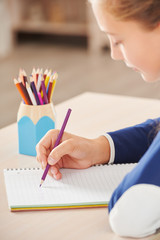 Close up of schoolgirl writing in her notebook