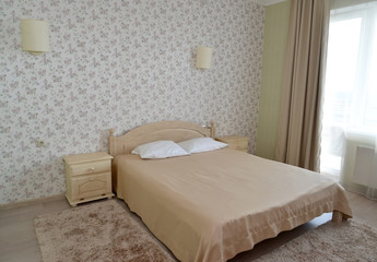 Fototapeta na wymiar Interior of a double hotel room in light tones with a double bed