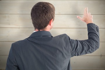 Composite image of businessman pointing with his fingers