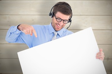 Composite image of businessman showing card wearing headset