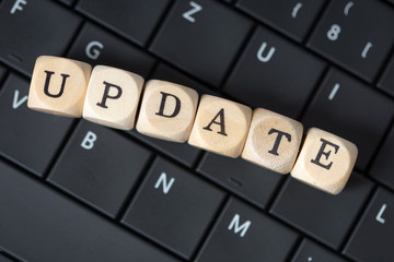 Tastatur und Holzwürfel mit dem Wort Update