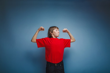 Naklejka premium boy teenager European appearance in a red shirt shows the power