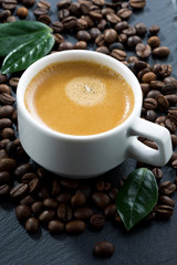 cup of espresso on coffee beans background, vertical, close-up