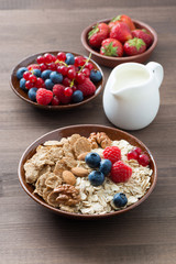 oatmeal and muesli in a bowl, fresh berries and milk