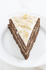 piece of chocolate cake with cream on a plate, vertical