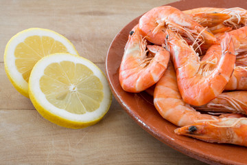 boiled shrimp with lemon arranged on kitchen board