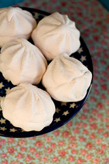 Delicate pink marshmallows lies in the blue plate with stars