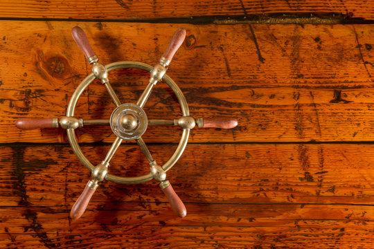 Brass Ship Wheel on Textured Wood