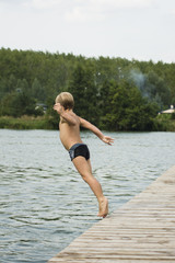 chłopiec skacze do wody