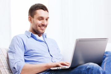 smiling man working with laptop at home