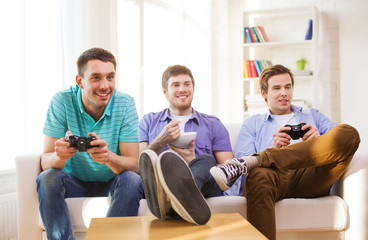 smiling friends playing video games at home