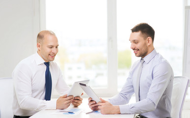 Fototapeta premium two smiling businessmen with tablet pc in office