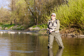 Fototapeta na wymiar woman fishing in the river in spring