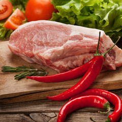 meat and pepper and spices on the table of the old boards
