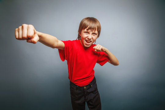 European-looking boy of ten years shows a fist, anger, danger, m