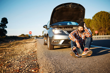 Car and driver man in beautiful sunny landscape. Portrait of sad