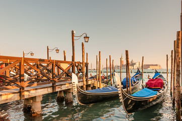 Gondolas docked to the poles on the Grand Canal in Venice.