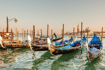 Gondolas docked to the poles on the Grand Canal in Venice.