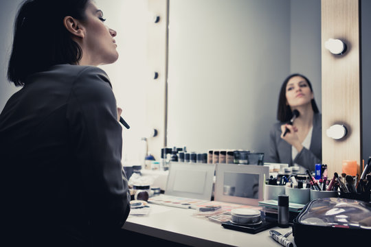 TV host/anchor/model applying makeup in dressing room