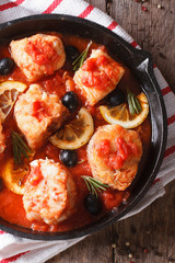 Fish fillet in tomato sauce in a pan close-up. vertical top view
