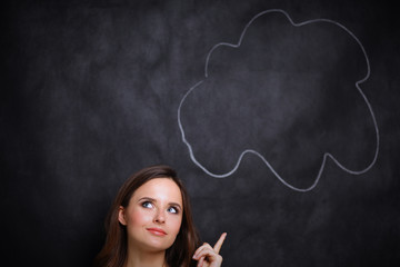 portrait of attractive girl thinking and pointing  up to blank