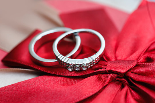 two wedding rings on red background