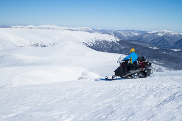 Man on snowmobile in winter mountain