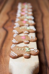 Gingerbread men in a row from the side on a wooden background