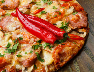 Delicious pizza with salami and chili peppers