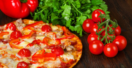 Delicious pizza with bacon, salami and cherry tomatoes