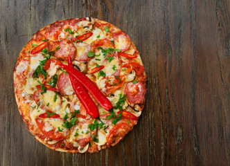 Delicious pizza with salami and chili peppers