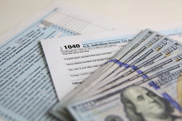 US Tax Form 1040 with new 100 US dollar bills
