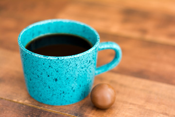 Teal coffee cup full of black coffee and chocolate